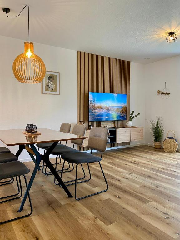 a dining room with a table and a tv at MeerZeit 20 in Wittmund