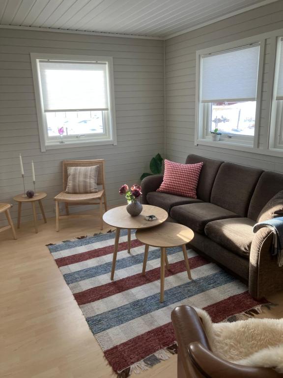 a living room with a couch and a table at Røssøyhytta in Steigen
