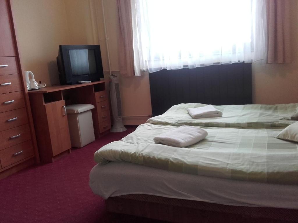 Postel nebo postele na pokoji v ubytování Domino Panzió
