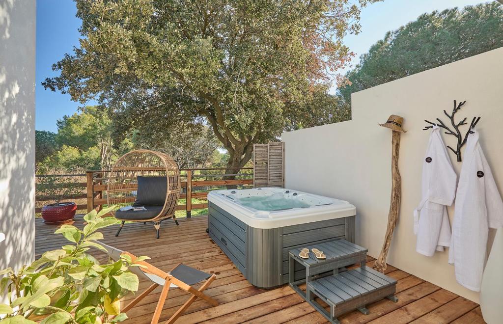a hot tub on a deck with a chair at Villa Spa privé golf in Servian