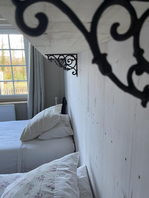 - une chambre avec un lit et une tête de lit en fer forgé dans l'établissement La Maison de Coutil, aux Gîtes de l'Etang des Noues, à Cholet