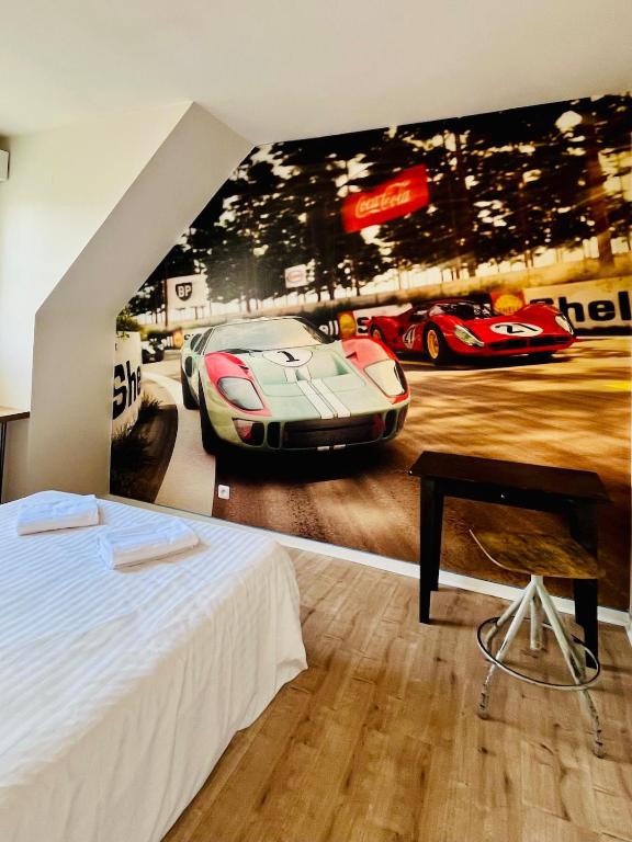 - une chambre avec une fresque murale représentant une voiture de course dans l'établissement Maison 1440 - STORIES, logement Atypique Sport Auto, au Mans