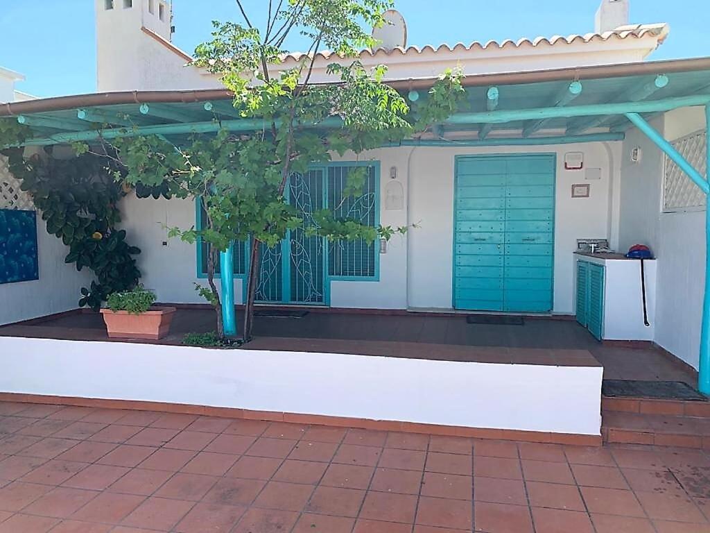 una casa con una porta blu e un patio di Villetta sul Mare incluso Accesso Stabilimento a San Felice Circeo