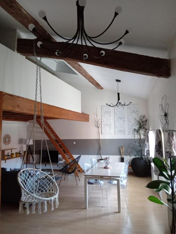 - un salon avec un lustre, une table et des chaises dans l'établissement LES GITES CHEROIS maison Esprit cabane 5 personnes, à Les Chères