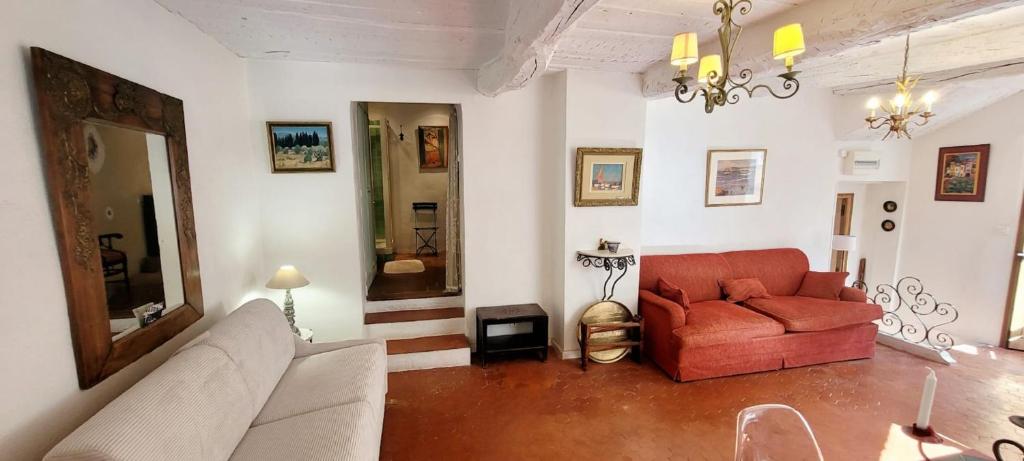 un salon avec un canapé rouge et un miroir dans l'établissement Studio in the village centre - Cogolin, à Cogolin