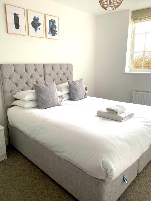 a bedroom with a large bed with white sheets and pillows at West Street Mews - Serviced Accommodation in Exeter
