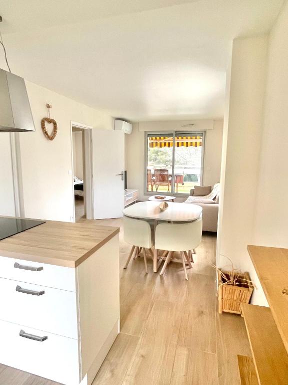 une cuisine et un salon avec une table et un canapé dans l'établissement Le Grand Estivale -3 terrasses-100m plage de sable, à Saint-Raphaël