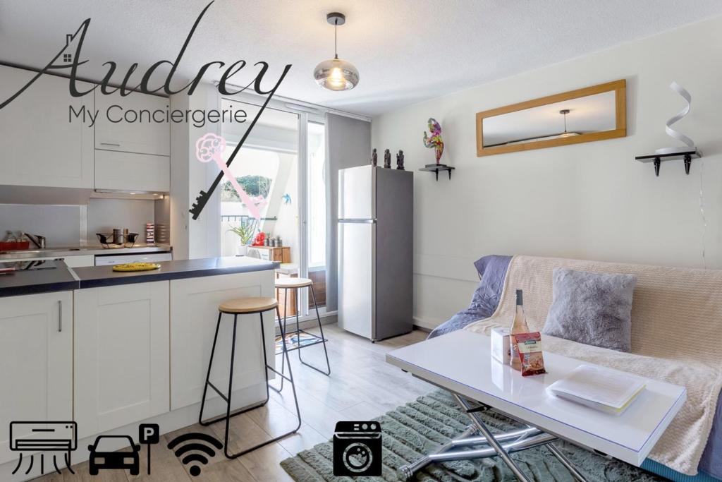 Il dispose d'une cuisine et d'un salon avec un canapé et une table. dans l'établissement Chez Hélène - Charmant deux pièces climatisé avec parking privé, à La Grande Motte