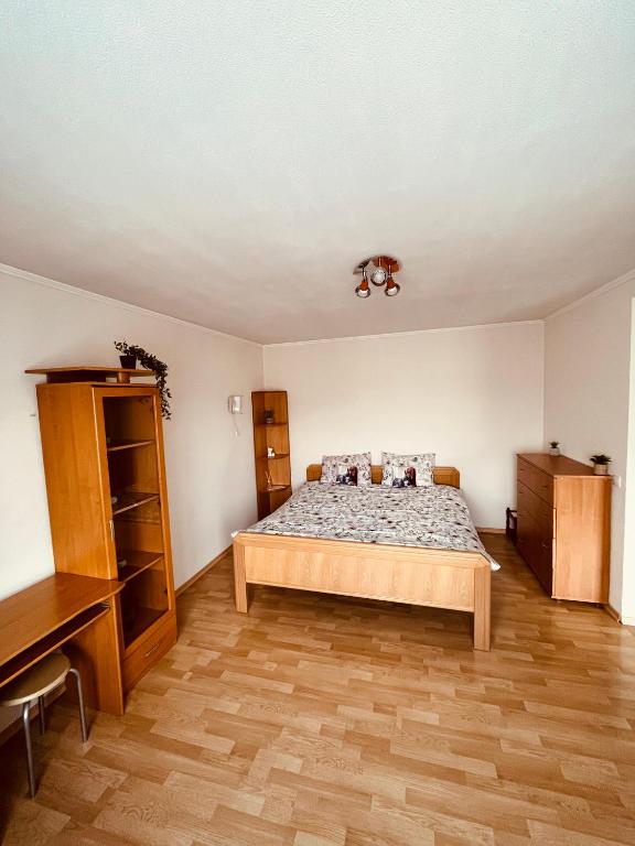 a bedroom with a bed and a wooden floor at Pilsētas Centra Tūristu Mītne in Daugavpils