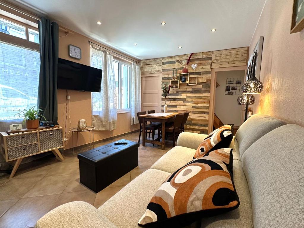 a living room with a couch and a table at Maison de bourg près du château in Polignac