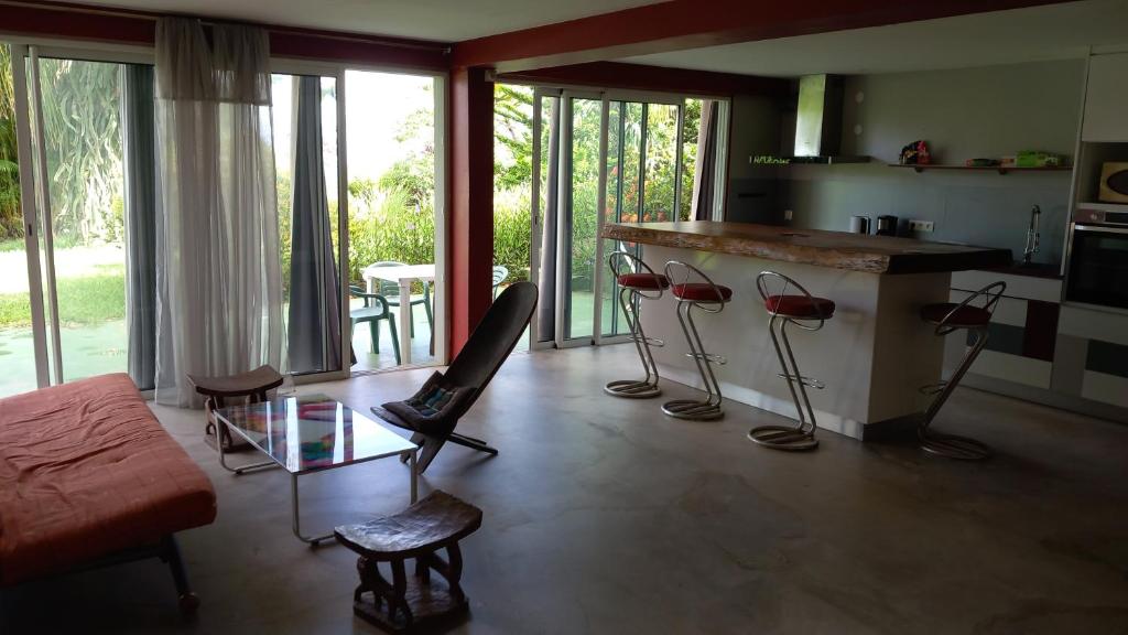 a living room with a bar with chairs and a counter at T2 de 70m2 avec terrasse en rez de jardin in La Possession
