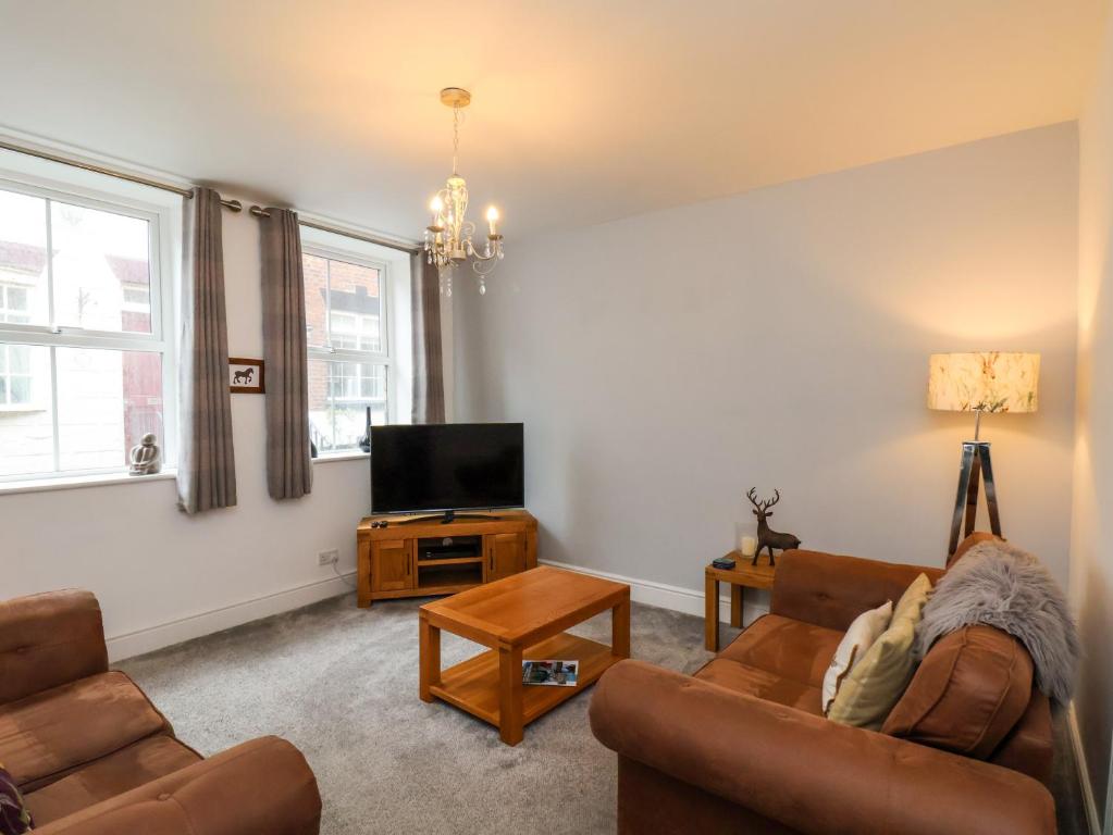 ein Wohnzimmer mit zwei Sofas und einem Fernseher in der Unterkunft The Bungalow in Whitby