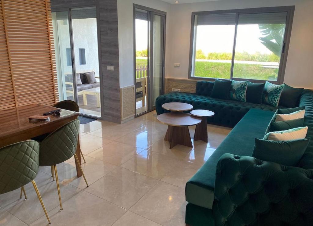 希迪布济德Appartement vue sur mer的客厅里有蓝色的沙发和一张桌子