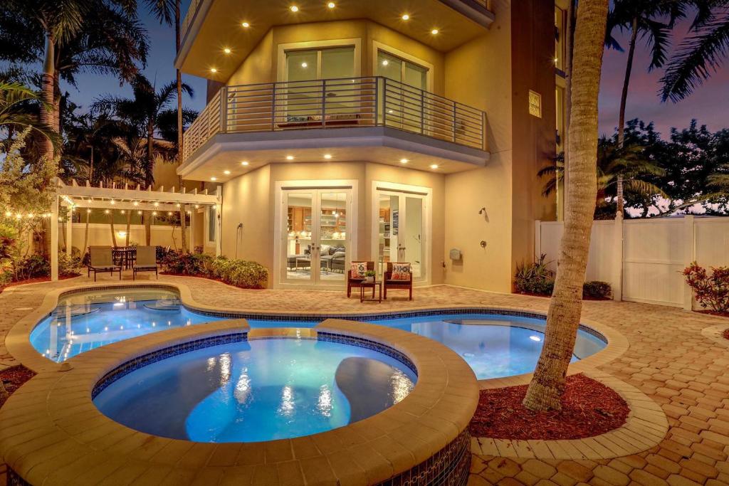 una casa con piscina delante de una casa en The Nia Tower Ultimate Beach House, en Pompano Beach