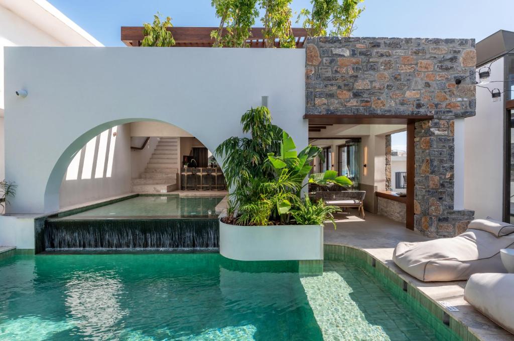 an indoor pool with a waterfall in a house at Elounda Stories Boutique Hotel in Elounda
