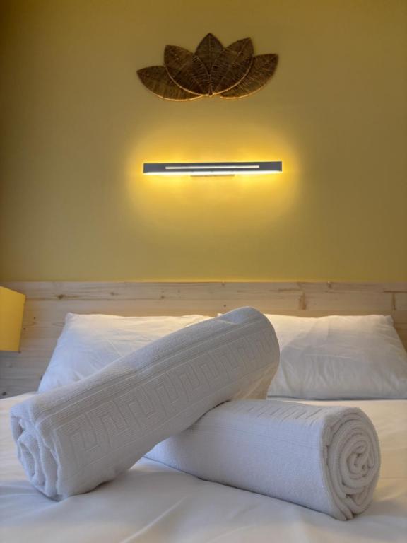 - un lit avec des serviettes et une lampe sur le mur dans l'établissement Le D'Artagnan - App 4 - Rez-de-chaussée, à Cazaubon