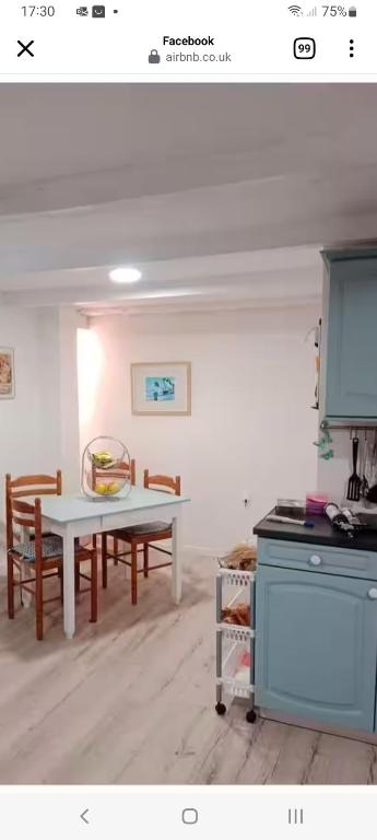 une cuisine avec une table et des chaises dans une pièce dans l'établissement La Cour, à Villefagnan