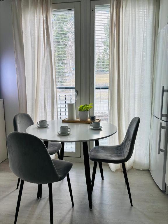 a table and chairs in a room with a window at Foliate Living Taimi in Jyväskylä