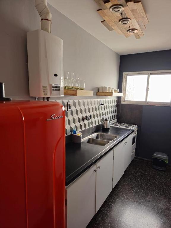 a kitchen with a red refrigerator and a sink at Departamento Primi in Mendoza