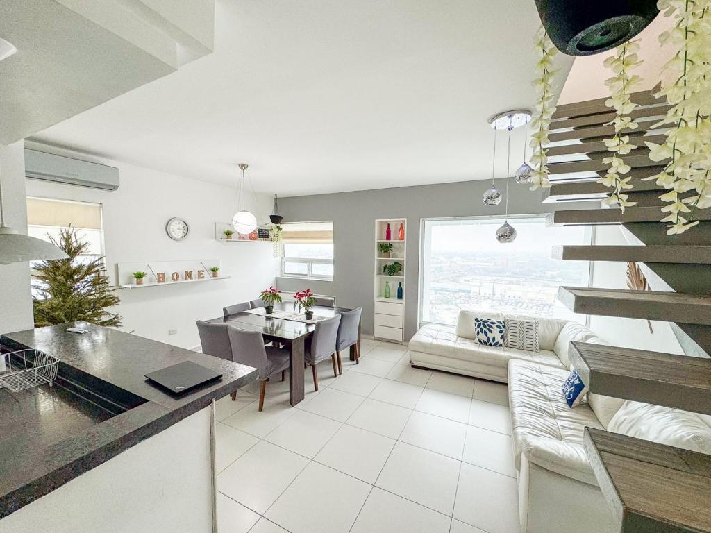 una cucina e un soggiorno con scala e tavolo di Penthouse w/ Terrace, Grill & City Views a Monterrey