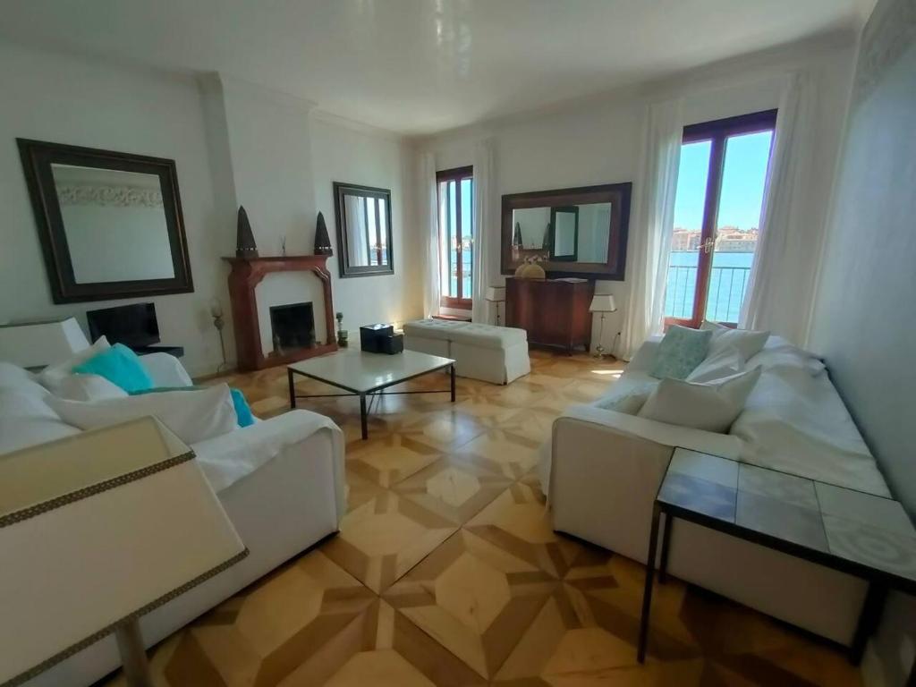 un soggiorno con 2 divani bianchi e un camino di La Grande Bellezza Deluxe House a Venezia