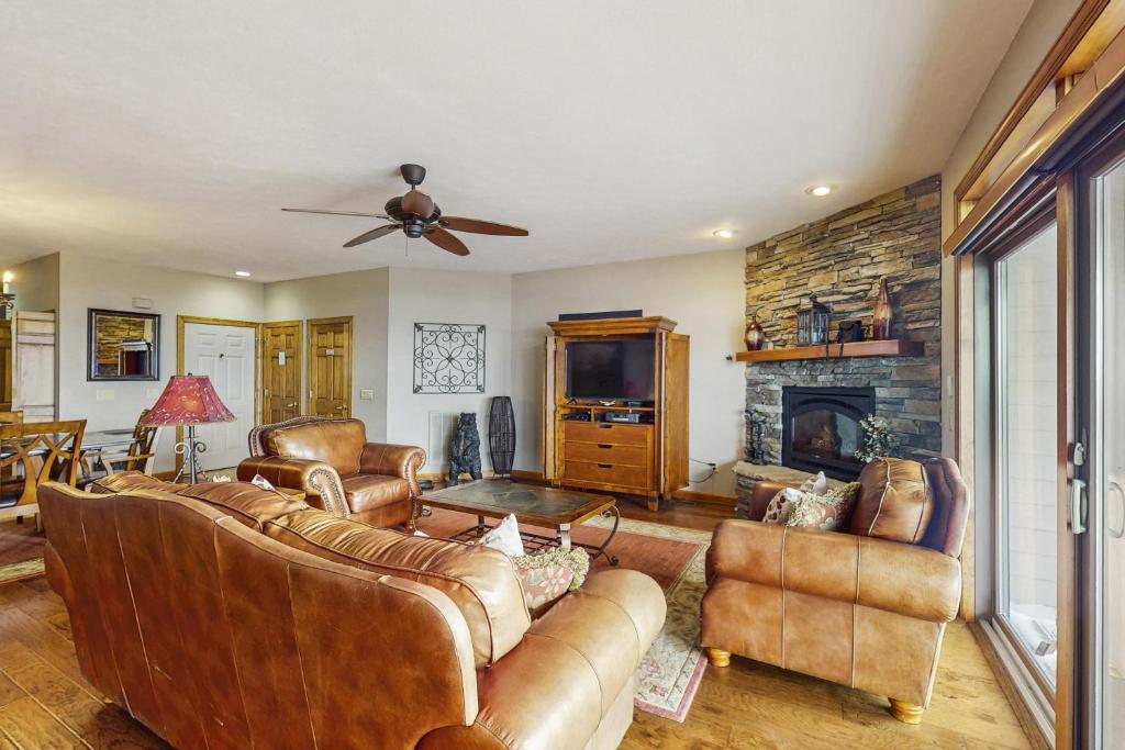 a living room with leather furniture and a fireplace at Reserve 19-D in Sugar Mountain