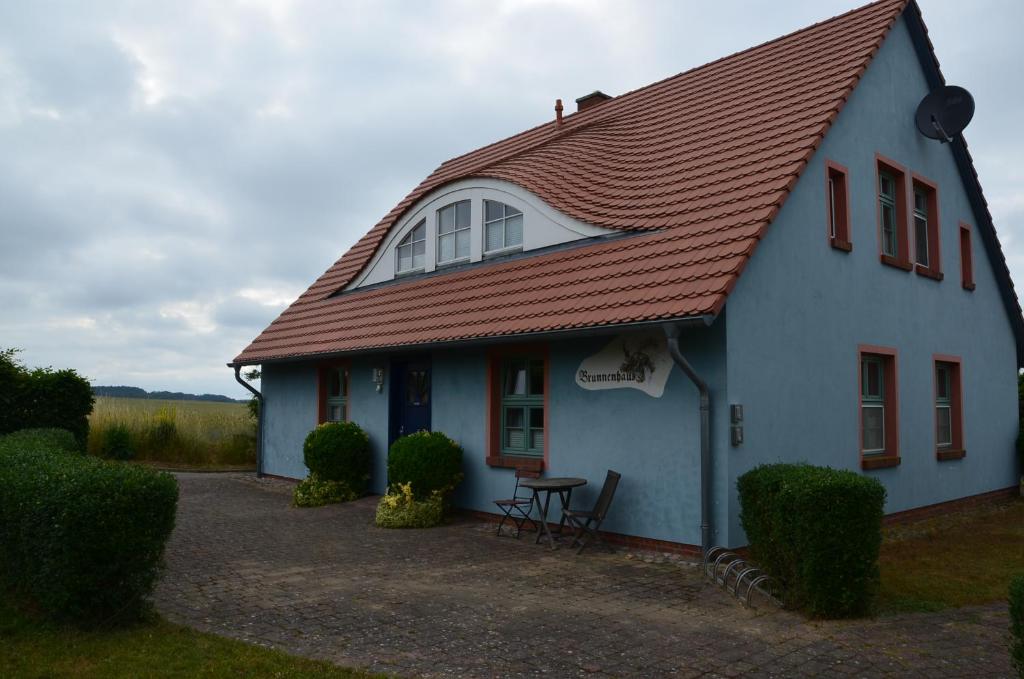 a white house with a red roof at Brunnenhaus Wohnung 1 in Mellenthin