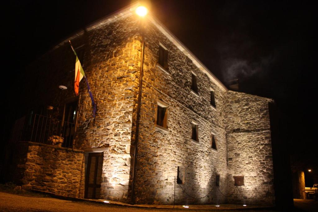 a light on the side of a castle at night at Agriturismo Il Casalone in Badia Tedalda