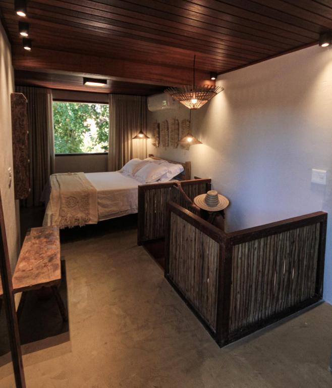 ein kleines Schlafzimmer mit einem Bett und einem Fenster in der Unterkunft Caraíva Villas de Jardel - Casa Jeri in Caraíva