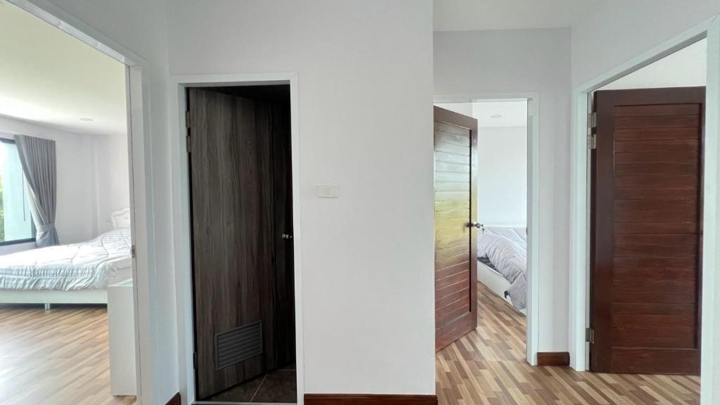 a room with a door and a bedroom with a bed at House at Hatyai Airport in Ban Thung Ri