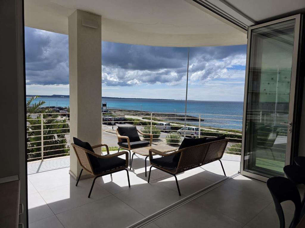 a balcony with a table and chairs and a view of the ocean at Appartamento Angolo Blu Fronte Mare in Gallipoli