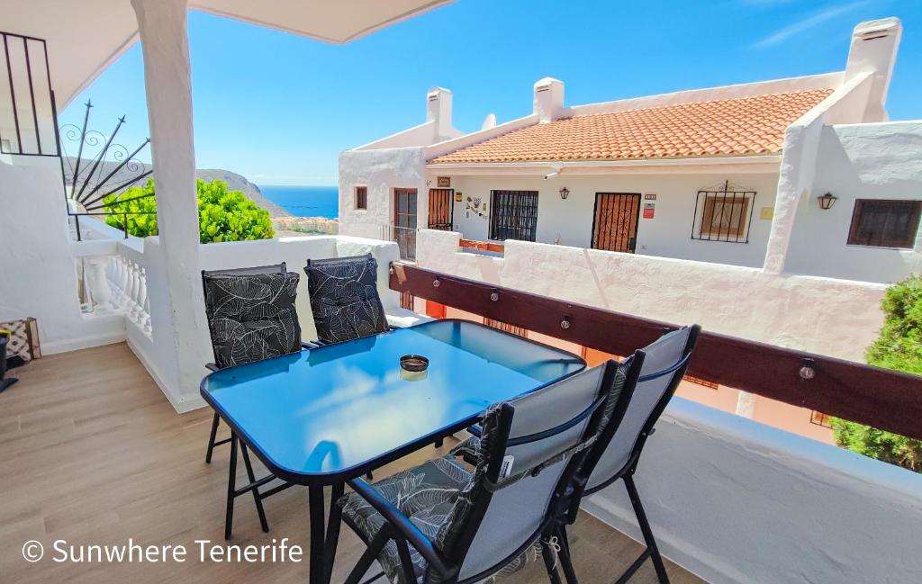 a patio with a blue table and chairs on a balcony at Cozy apartment with wonderful view - Los Cristianos in Arona