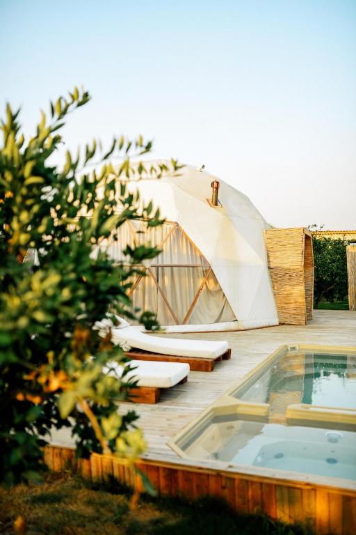a tent is sitting on a deck next to a swimming pool at Mandalin Glamping in Selçuk