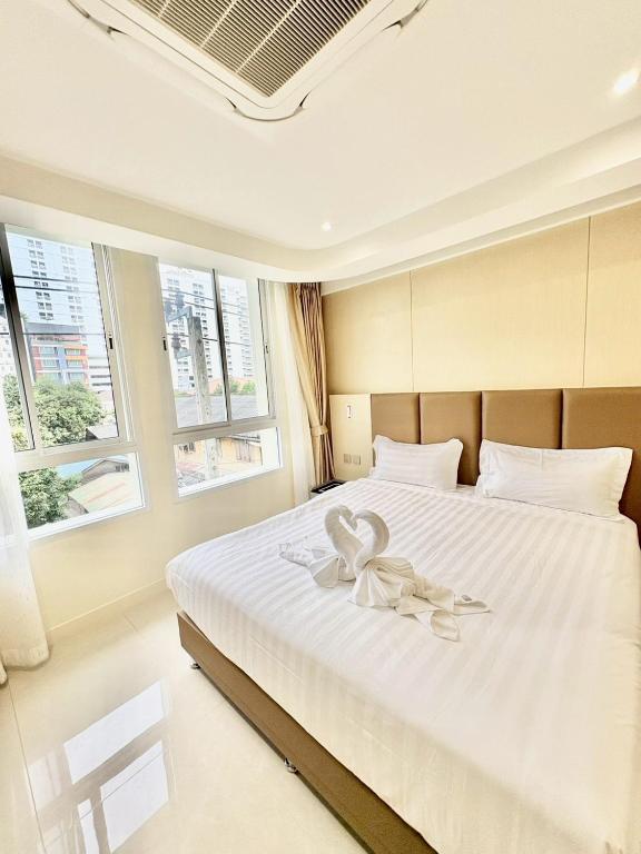a bedroom with a large white bed with a flower on it at ABCQQ Hotel Bangkok in Bangkok