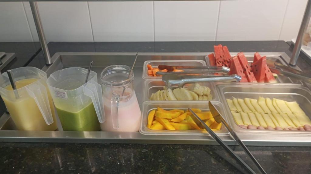 a lunch box with containers of food and drinks at Hotel União in Pojuca