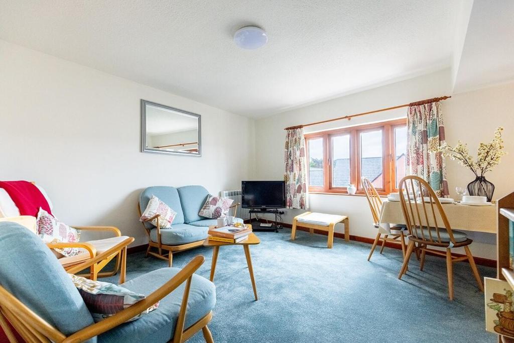 a living room with a couch and chairs and a table at KATHERINES COURT - Spacious Apartment with Rolling Hill Views in Kendal