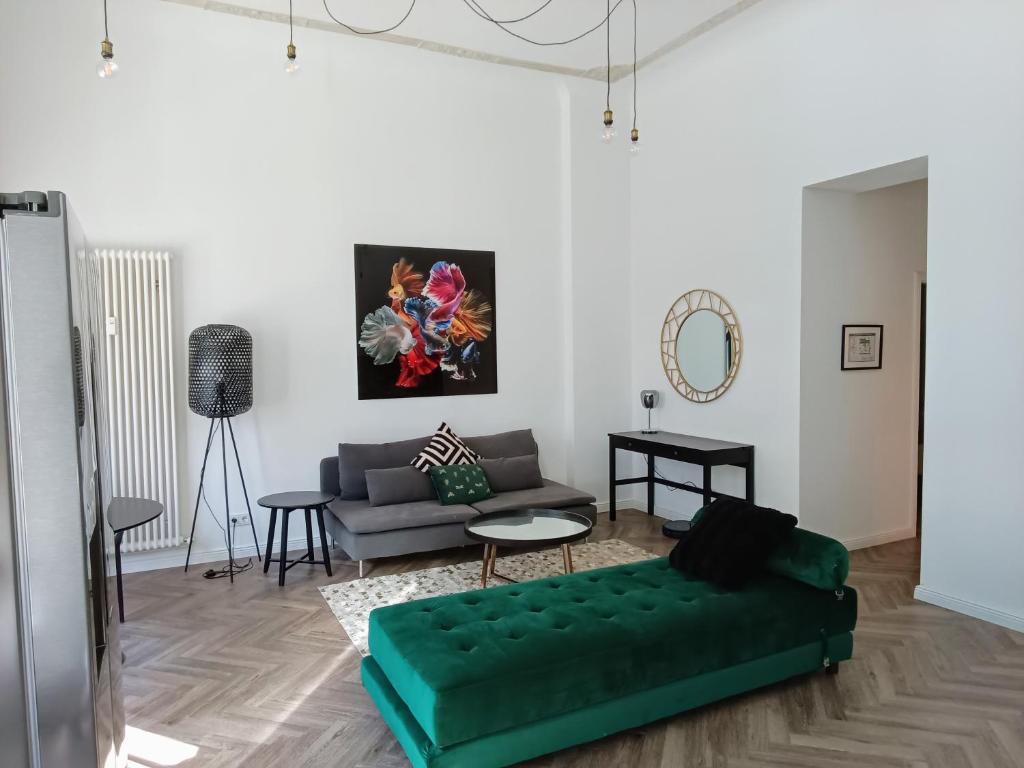 Hotel Loft nahe Schloss Charlottenburg, a living room with a green couch and a table at Loft nahe Schloss Charlottenburg in Berlin