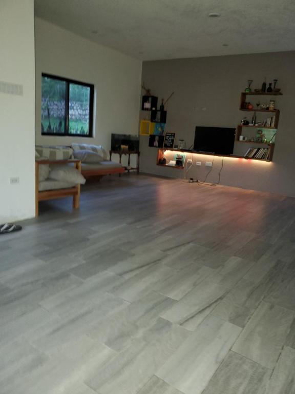 een lege woonkamer met een houten vloer bij RJs Ranch in Ocho Rios