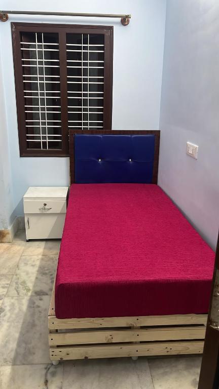 1 dormitorio con 1 cama grande con colchón rojo en Ayaan Home stay, en Bangalore