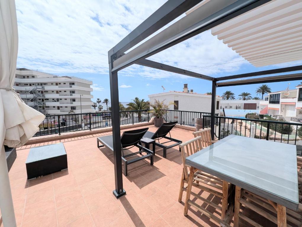 a patio with a table and chairs on a balcony at Luxury & Panorama Apartment in Costa de Adeje