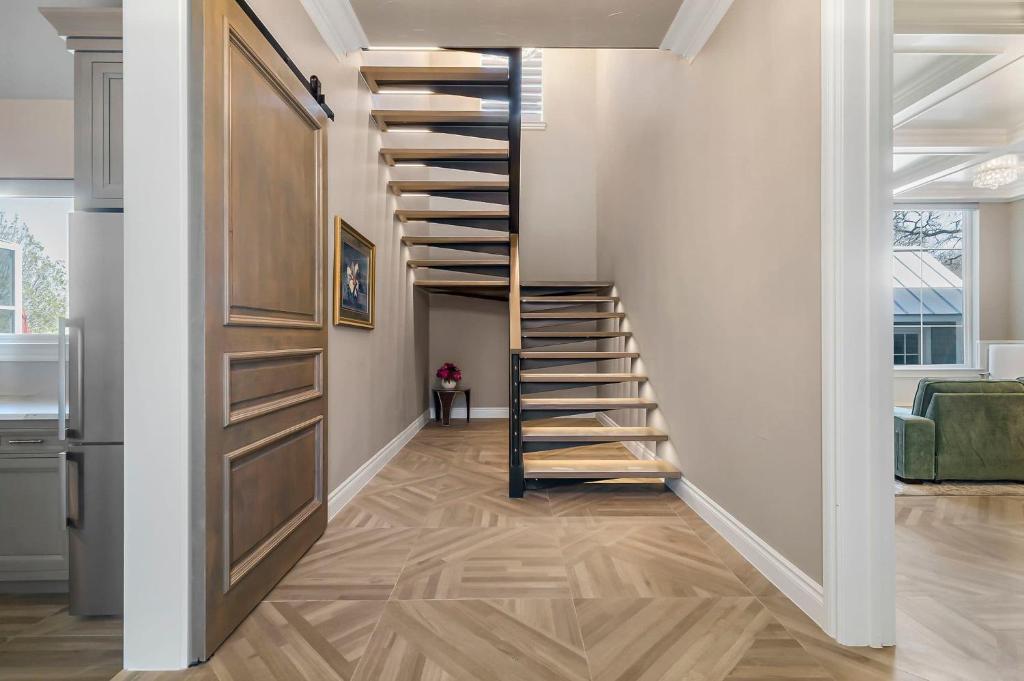 a spiral staircase in a living room with wooden floors at Lazy River Ranch - Lazy River Pool, Golf & Pickleball in Kreutzberg