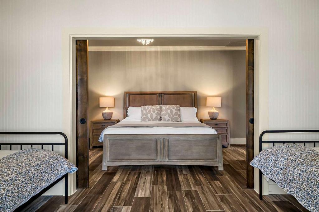 a bedroom with a large bed and two twin beds at Lazy River Ranch - Lazy River Pool, Golf & Pickleball in Kreutzberg