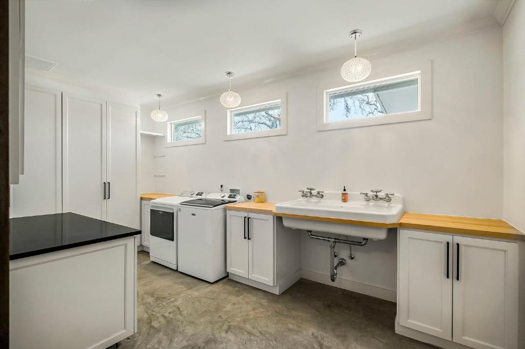 a white kitchen with a sink and a stove at Lazy River Ranch - Lazy River Pool, Golf & Pickleball in Kreutzberg