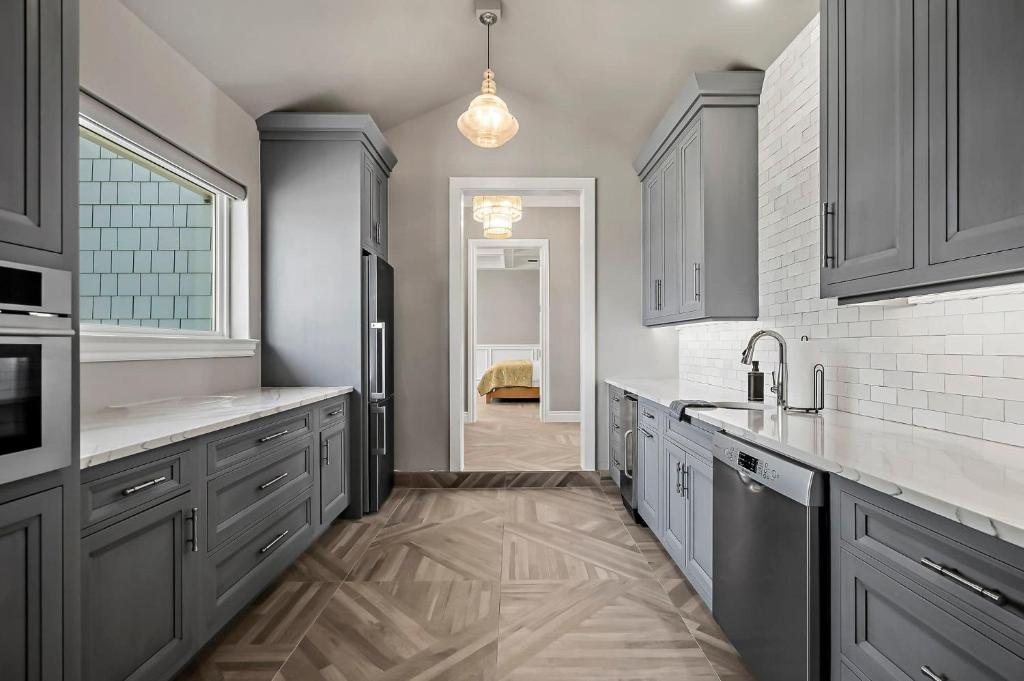 a large kitchen with gray cabinets and a sink at Lazy River Ranch - Lazy River Pool, Golf & Pickleball in Kreutzberg