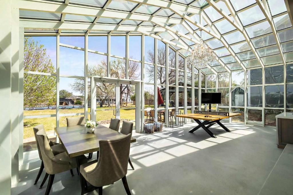 a glass house with a table and a ping pongetitive at Lazy River Ranch - Lazy River Pool, Golf & Pickleball in Kreutzberg