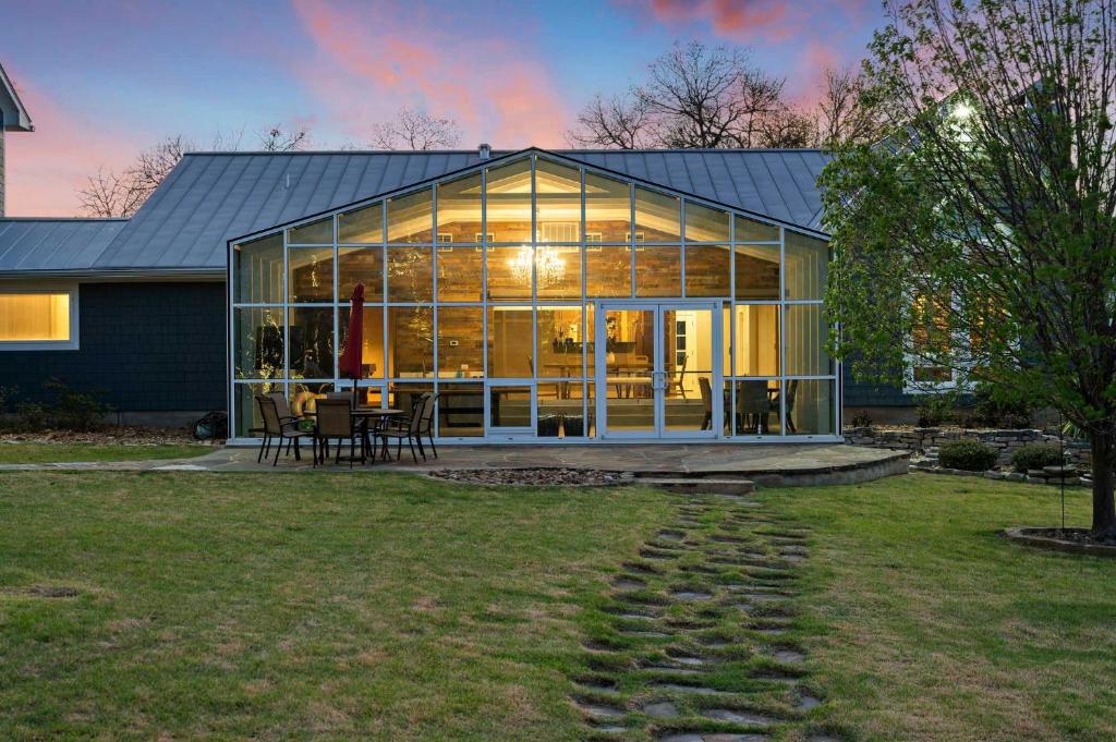 a large glass house with tables and chairs in a yard at Lazy River Ranch - Lazy River Pool, Golf & Pickleball in Kreutzberg