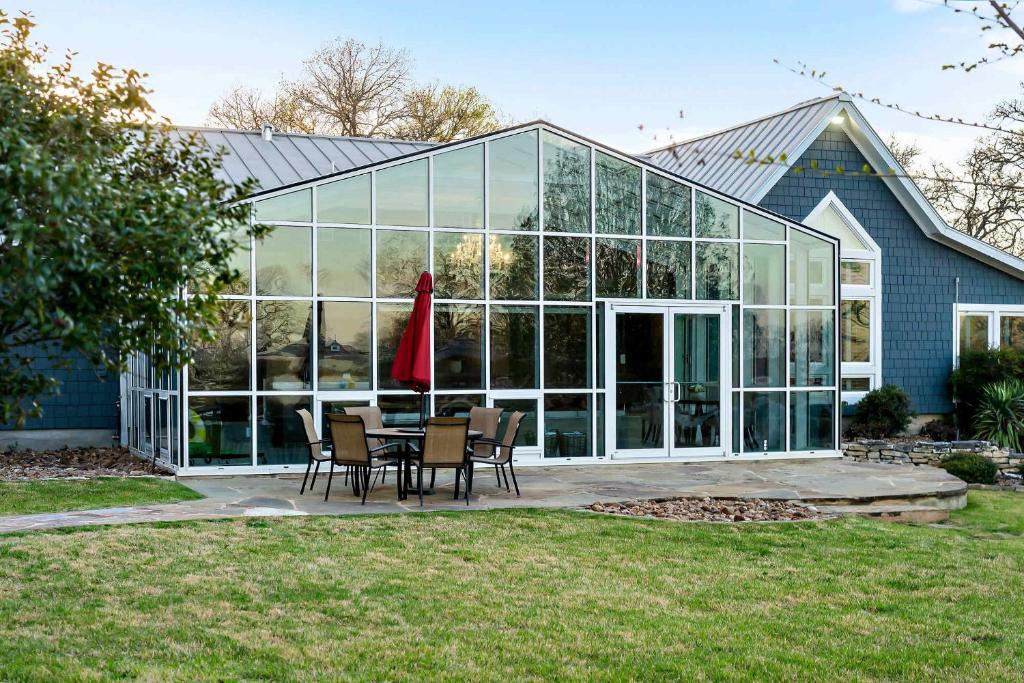 a large glass house with a table and chairs at Lazy River Ranch - Lazy River Pool, Golf & Pickleball in Kreutzberg