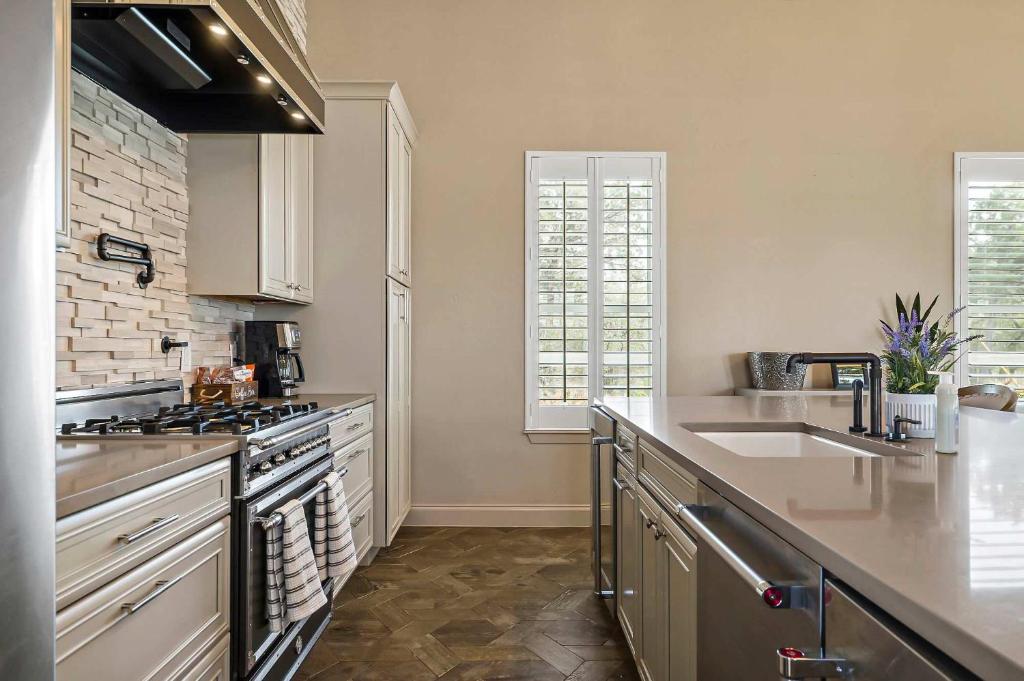 a kitchen with white cabinets and a stove top oven at Lazy River Ranch - Lazy River Pool, Golf & Pickleball in Kreutzberg