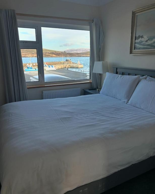 a bedroom with a large bed and a large window at Oliver&#39;s Seafood Bar in Cleggan
