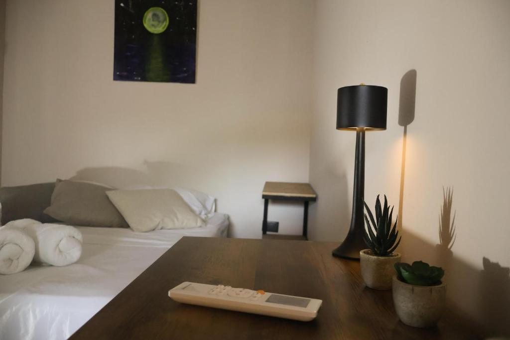a room with a bed with a table and a lamp at Casa Nocodesa in Nicoya